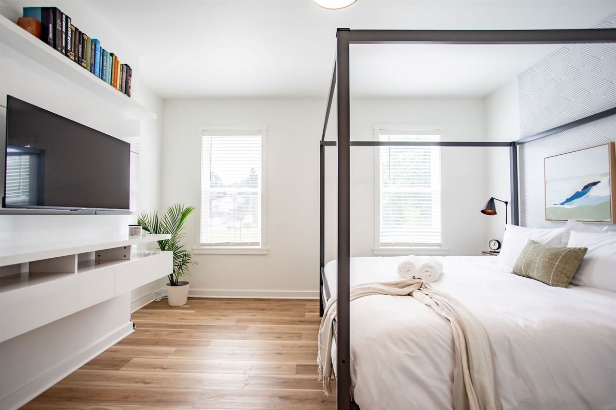 Comfortable bedroom with a TV positioned directly in front of the bed, creating the perfect setup for watching your favorite shows or movies from the comfort of your pillow.