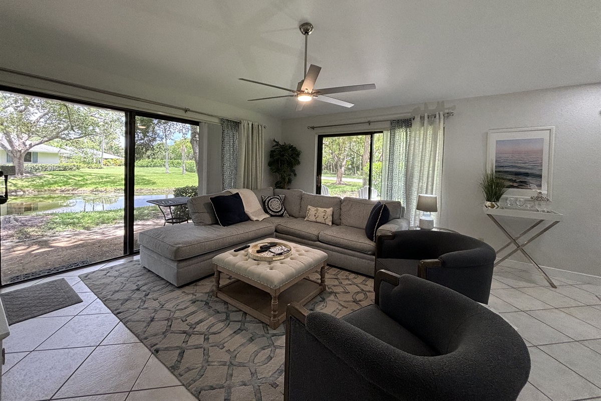 Our large, open living room has seating for six in front of the TV. Two large sliding glass doors let in plenty of light and views of the surrounding, peaceful landscaping.