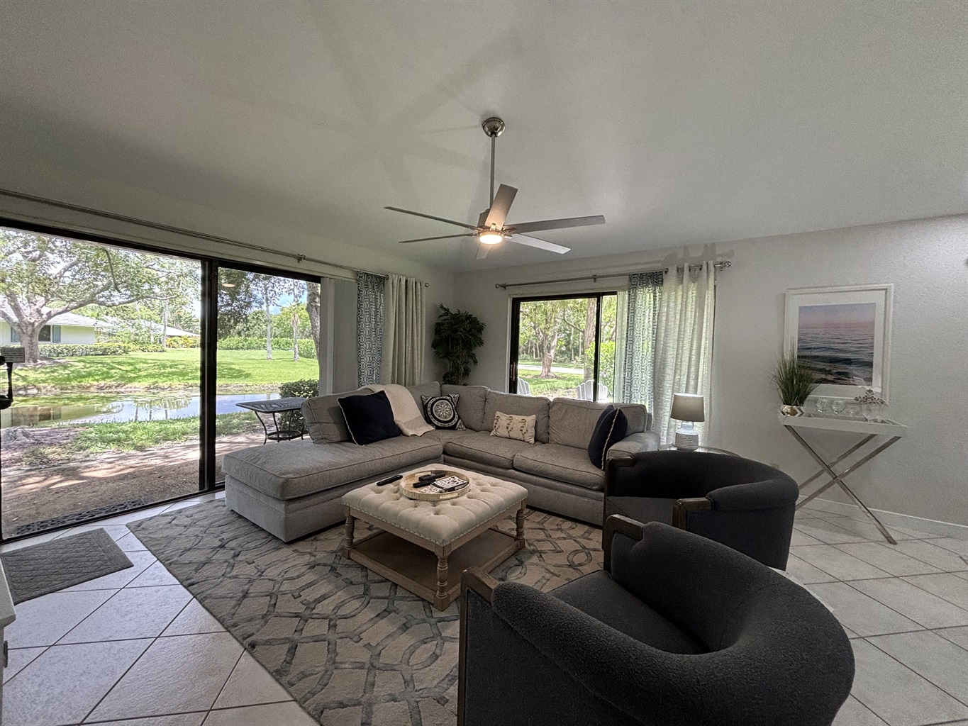 Our large, open living room has seating for six in front of the TV. Two large sliding glass doors let in plenty of light and views of the surrounding, peaceful landscaping.