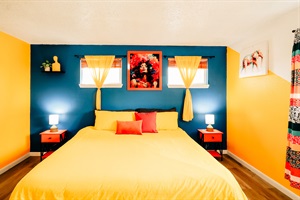 A cozy arrangement featuring plush yellow and red pillows, flanked by two lamps casting a soft, inviting glow.