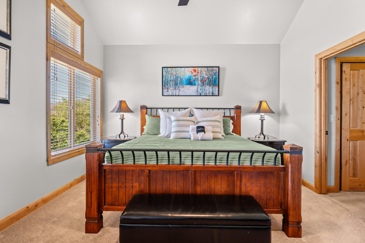 Bright and airy primary bedroom with vaulted ceilings and mountain charm.