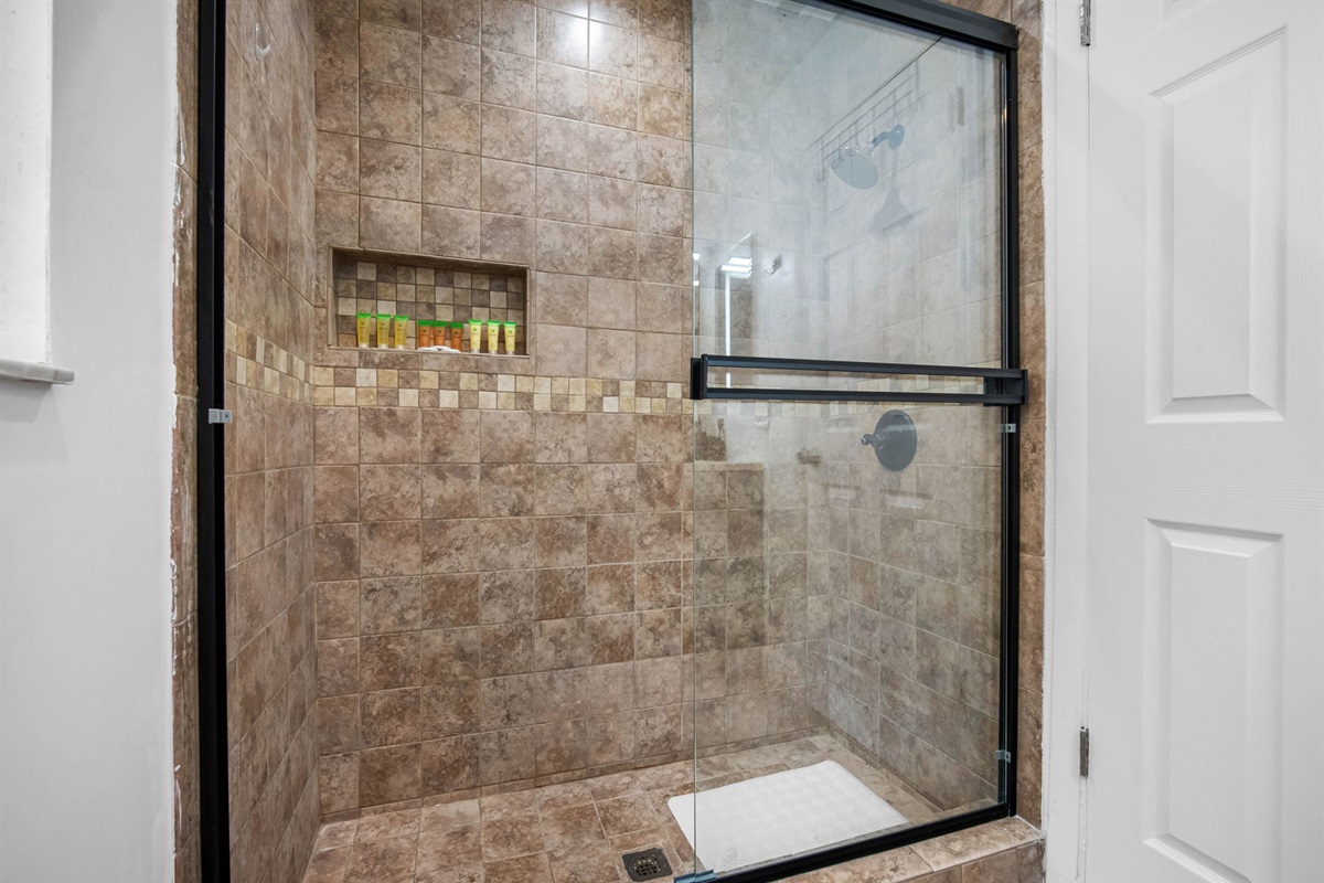 Glass shower doors, quality finishes, and a framed mirror elevate this space above the average rental bath.
