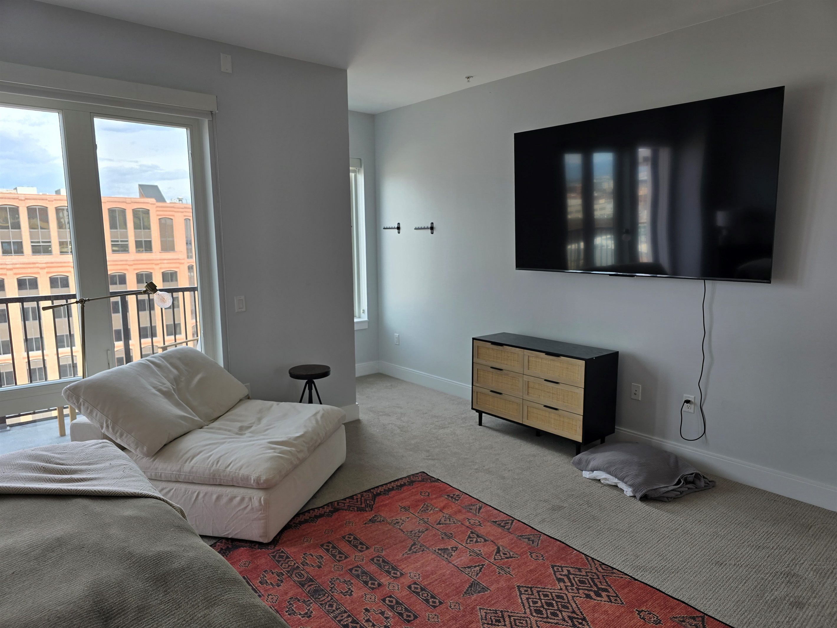 King size bed, extra seating area, clothes hanging in nook off of the main bedroom.