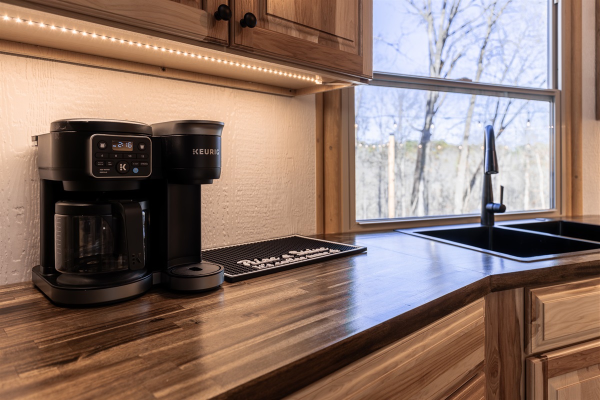 Start your morning with fresh coffee and peaceful forest views from the kitchen sink