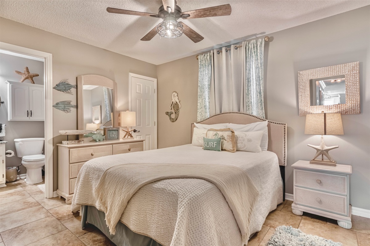 Master bedroom with queen bed, smart TV, ceiling fan, and ensuite bathroom