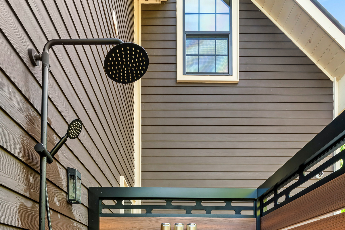 Experience a unique luxury amenity during your stay. The enclosed outdoor shower combines high-end matte fixtures with rustic wood siding, offering a beautiful, private place to unwind.