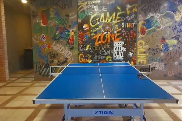 Challenge your friends to a match in this vibrant game room featuring a ping pong table.