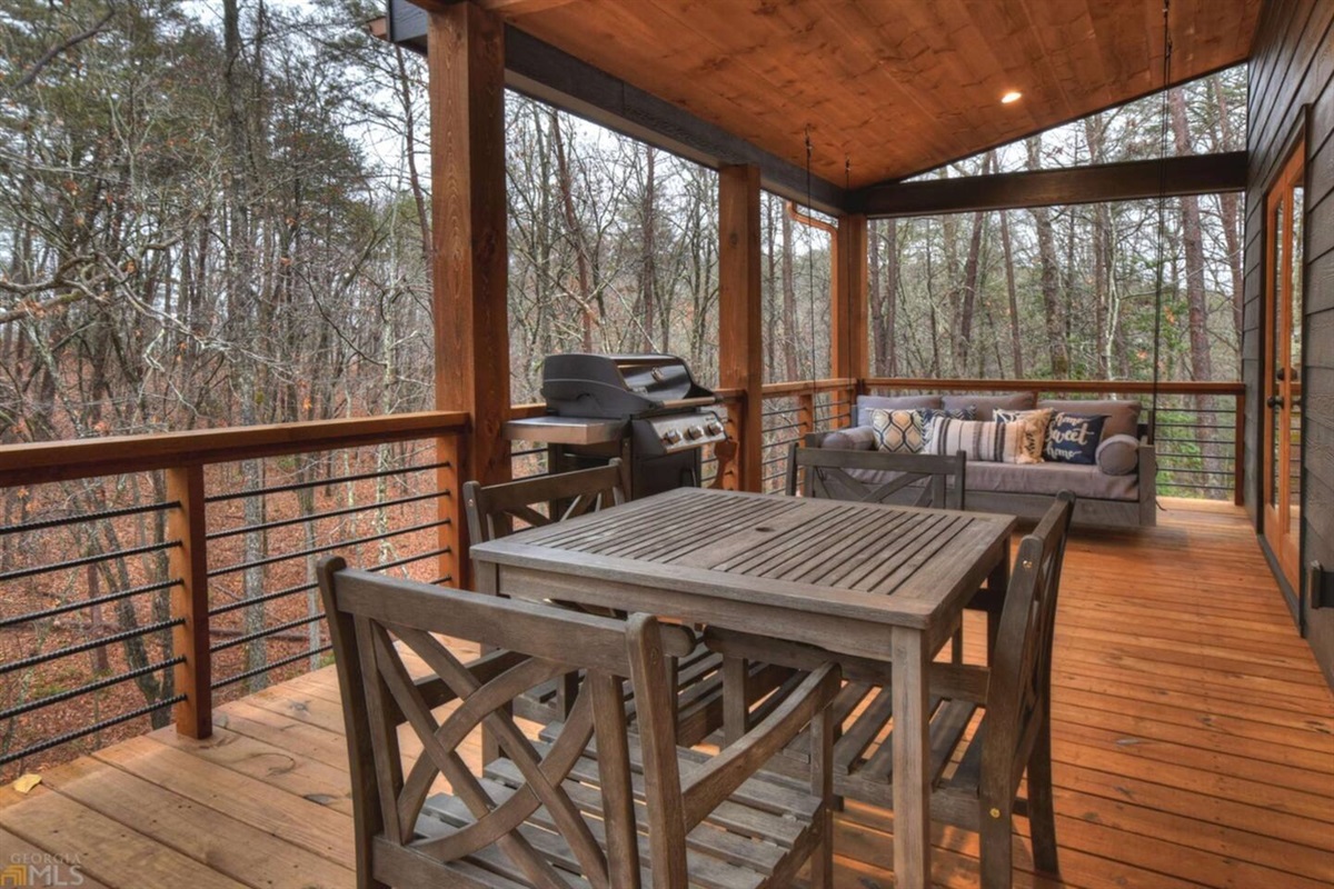 Main floor outdoor dining area, grill and swing.  Outdoor fireplace and additional seating is also on this level.