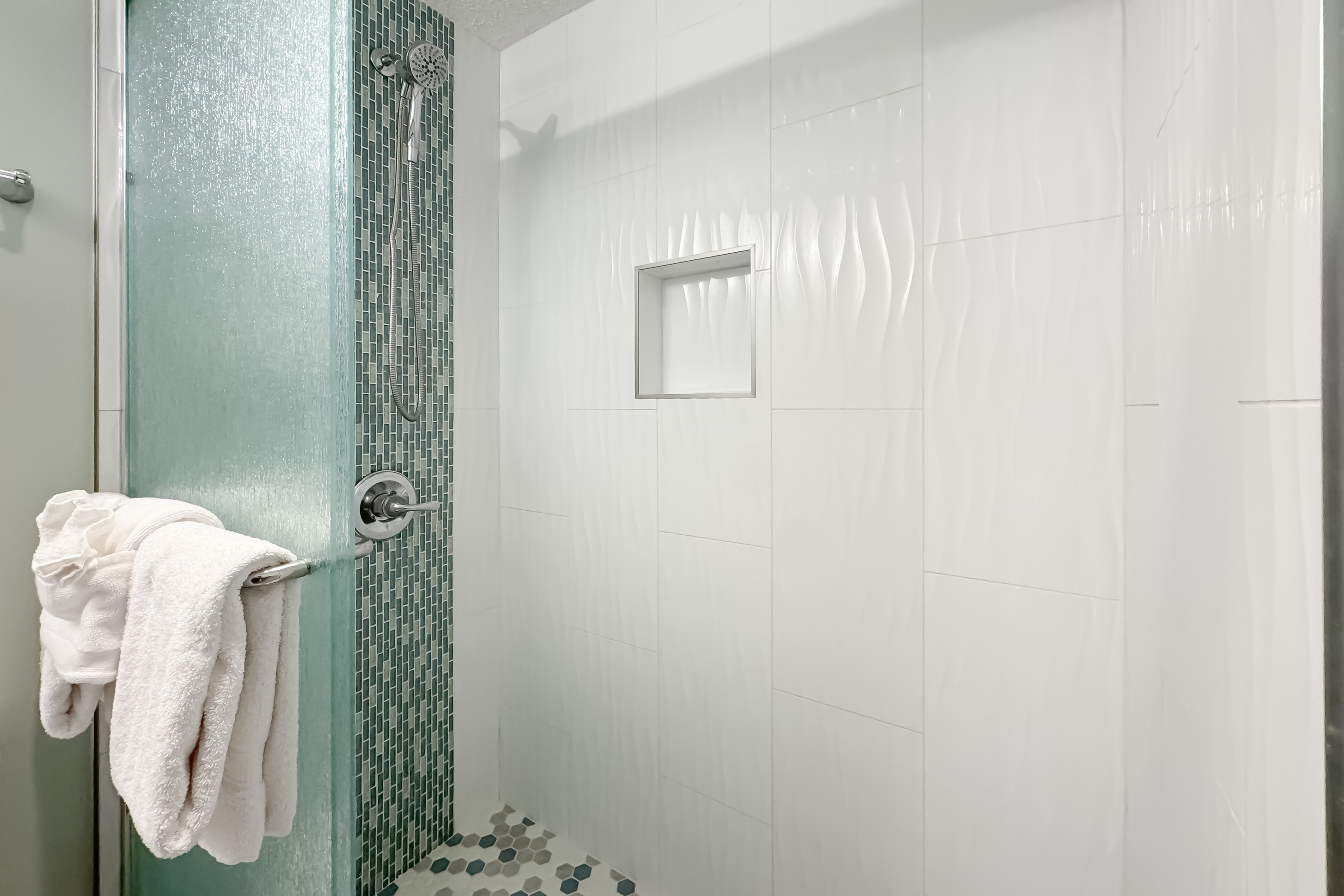 Freshly updated bathroom featuring an elegantly tiled walk-in shower, ample vanity space, and modern fixtures.