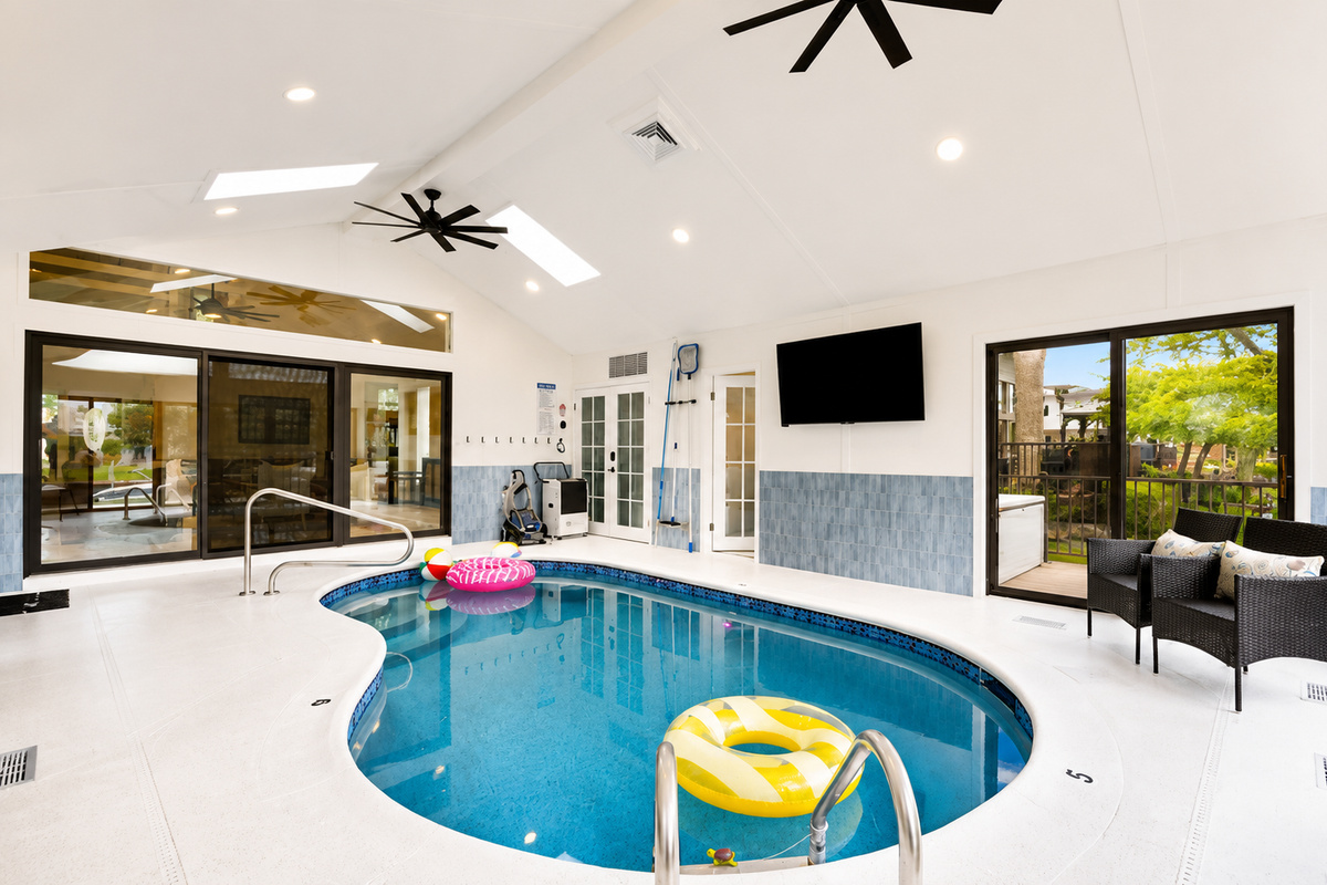 Year-round fun awaits in this stunning indoor heated pool room, featuring vaulted ceilings, skylights, abundant natural light, and a spacious resort-style design perfect for relaxing, swimming, and creating unforgettable memories with family and friends.
