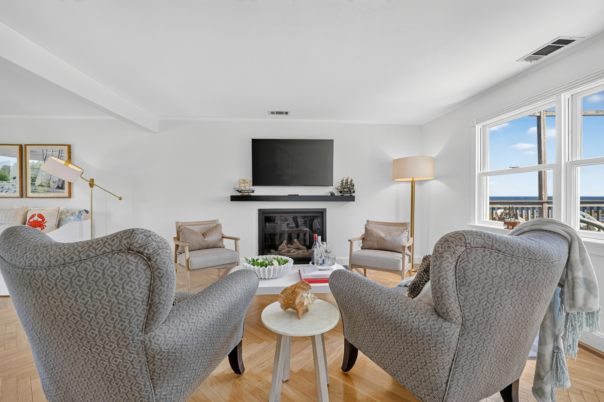 Bright and inviting living room featuring comfortable seating, a fireplace, Smart TV, and spectacular ocean views.