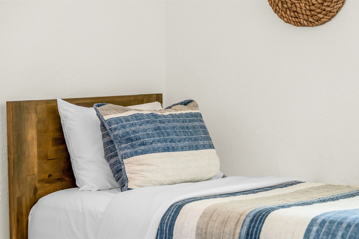 Bedroom 4 features cozy twin beds with nautical-inspired decor and soft coastal tones, perfect for kids, friends, or guests seeking a bright and cheerful space to unwind.
