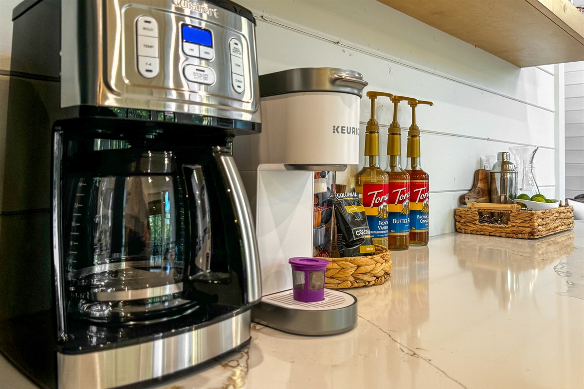 Coffee bar with drip coffee pot or single serve Keurig, a selection of flavored syrups, and start up supply of sugar, creamer and coffee.  