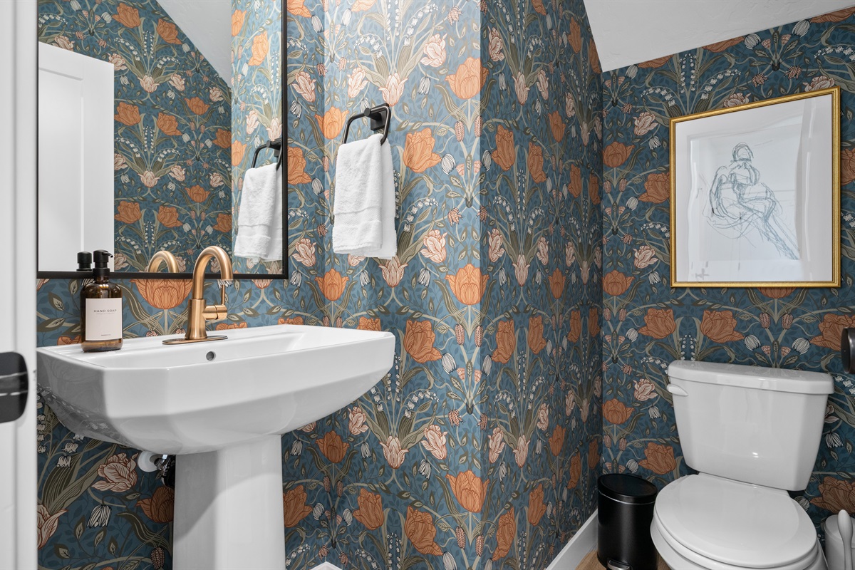 Charming half bath with bold floral wallpaper and modern fixtures.