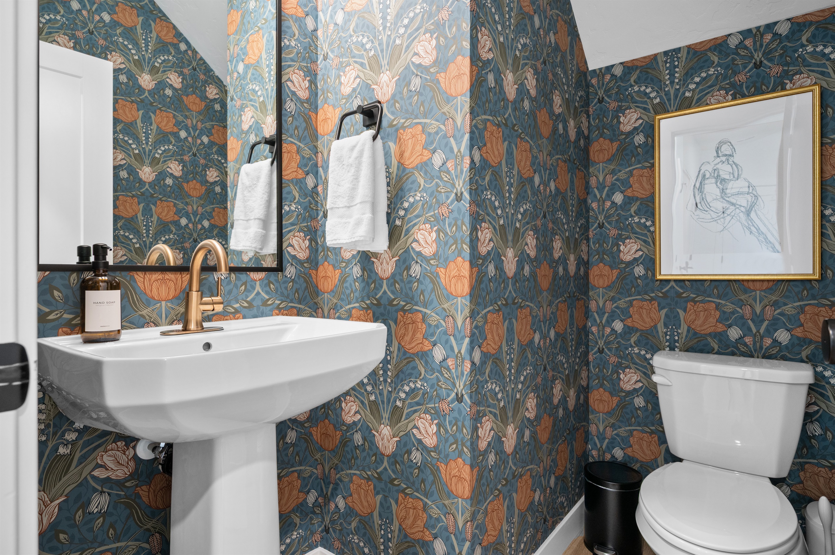 Charming half bath with bold floral wallpaper and modern fixtures.