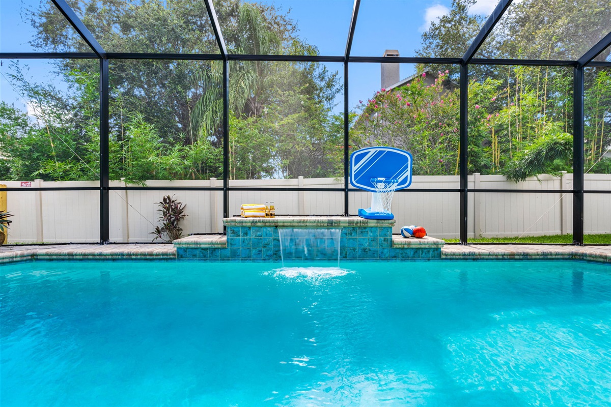 Enjoy the outdoors without the bugs! This screened-in pool area features serene water features, sports games, and ample space to swim or unwind.