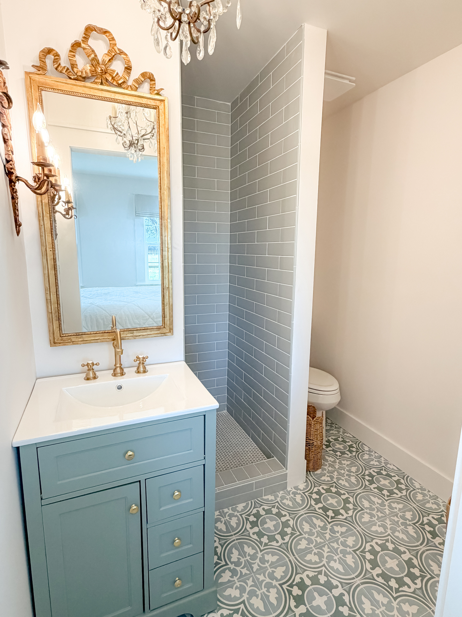 Elegant master bathroom with an ornate vintage mirror, warm lighting, and timeless designer details.