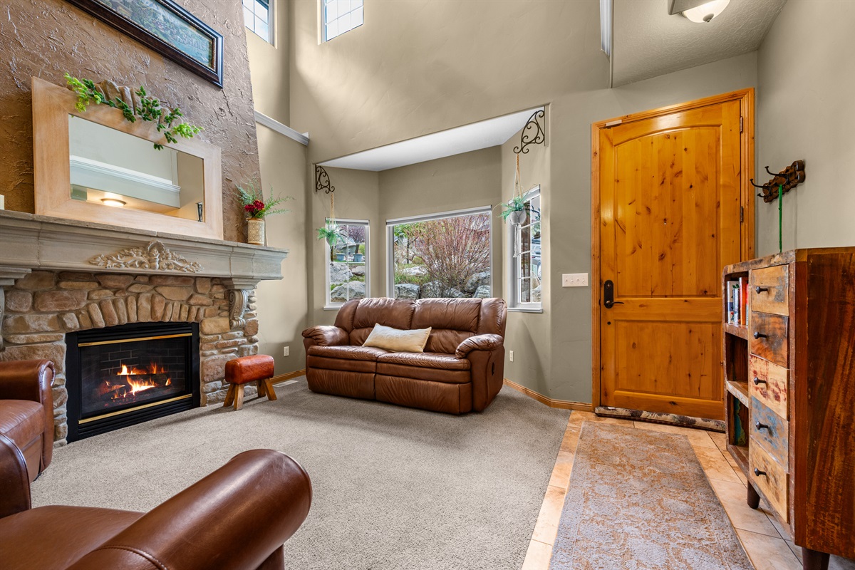 Step into warmth and comfort with soaring ceilings and a cozy fireplace welcoming you home.