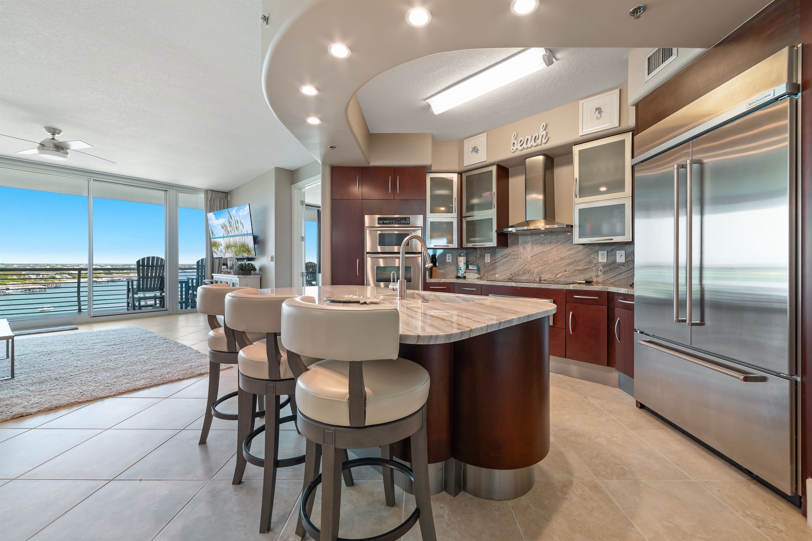 The modern kitchen island with bar seating offers a casual dining option, while the open layout maximizes natural light and showcases the stylish finishes throughout.