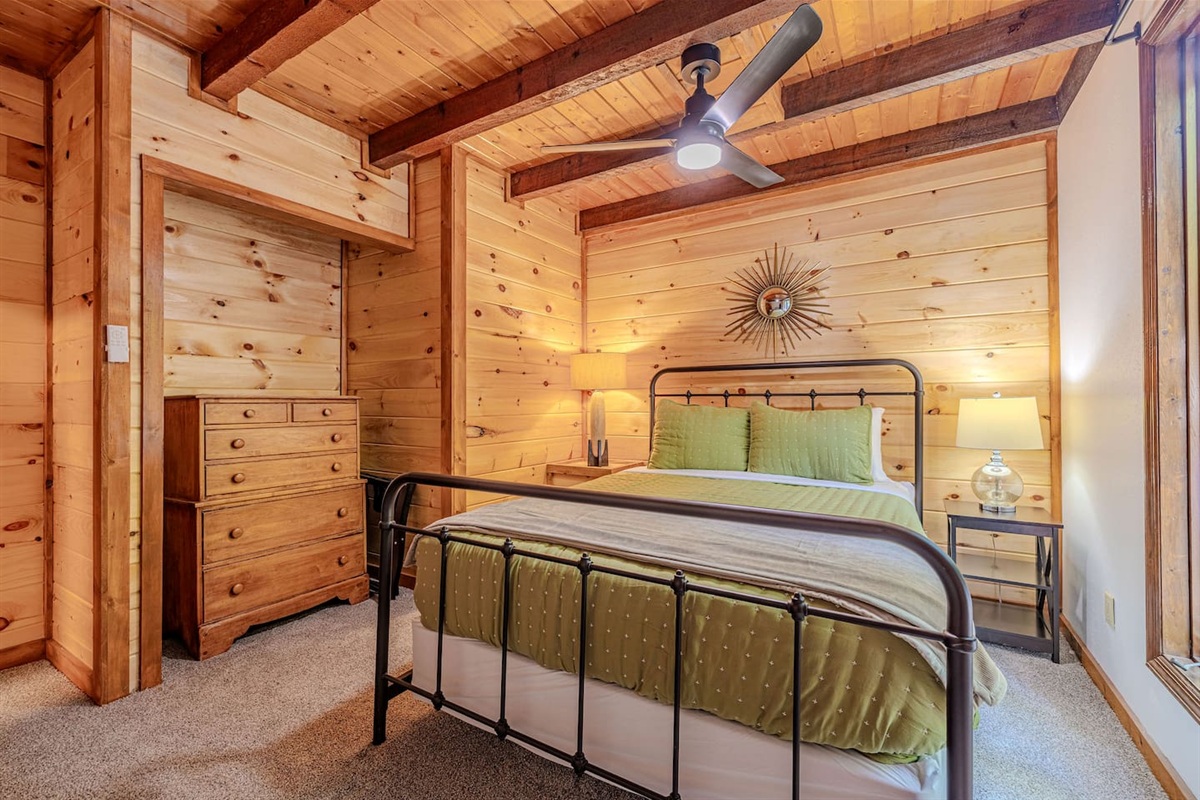 The main-floor queen suite blends cozy comfort with thoughtful details, creating a relaxed space to unwind after a day in the Smokies.