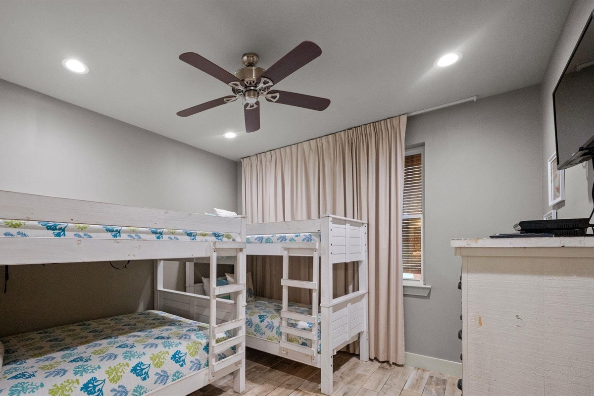 Bedroom with Full over full bunk bed and twin over twin bunk bed  ceiling fan, TV and en-suite bathroom 