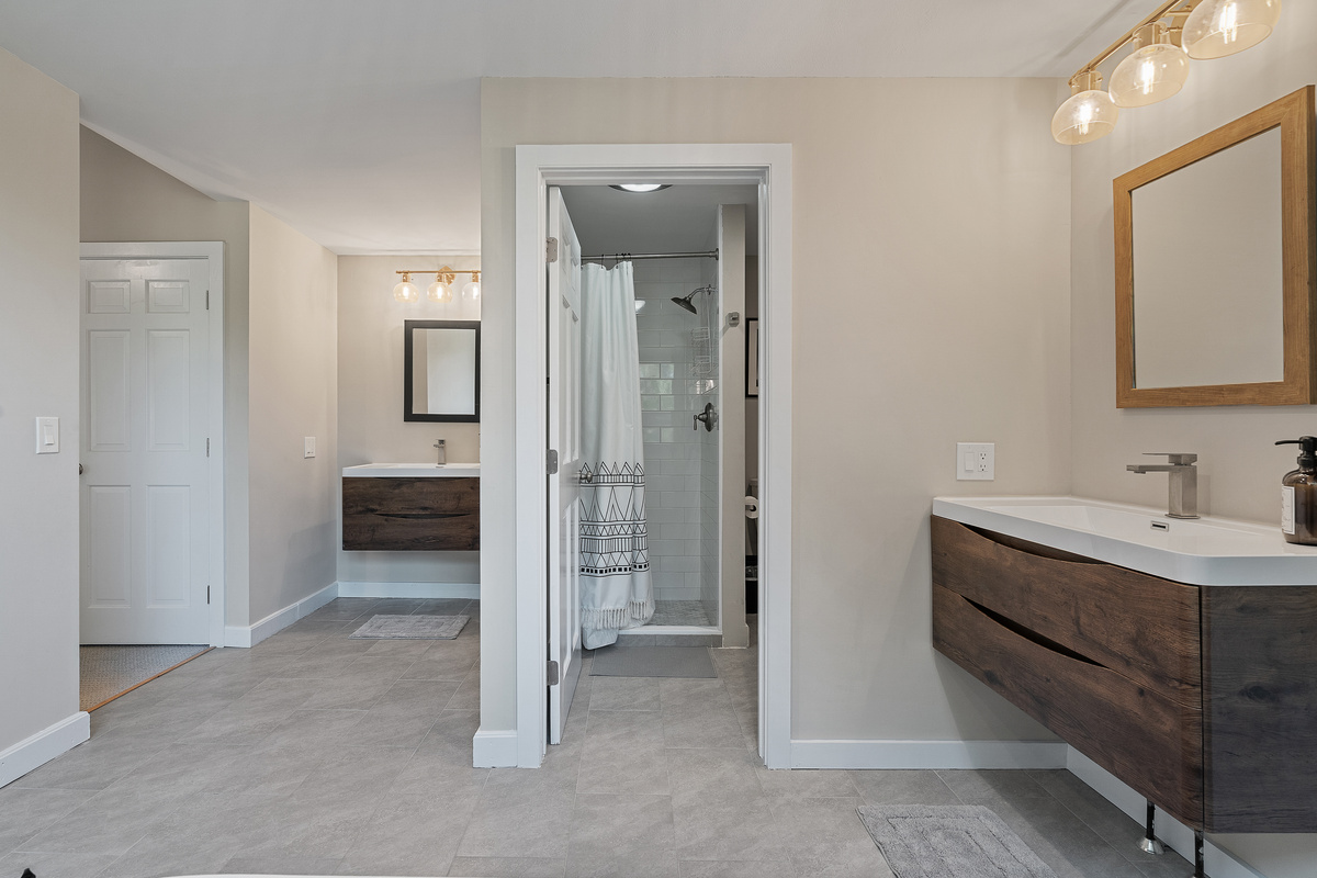 En-suite bathroom with floating wood vanity adjoining the primary bedroom