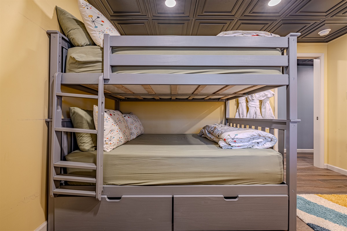 Maximize your group's stay with our sturdy grey bunk beds, complete with premium linens and a sophisticated dark coffered ceiling.