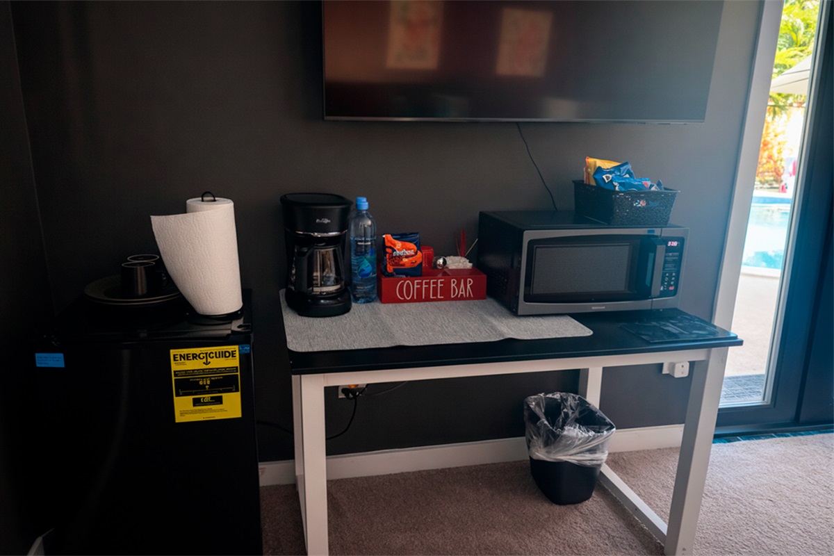 In-room amenities in The Red Room, including a coffee station, microwave, mini fridge, and flat-screen TV.