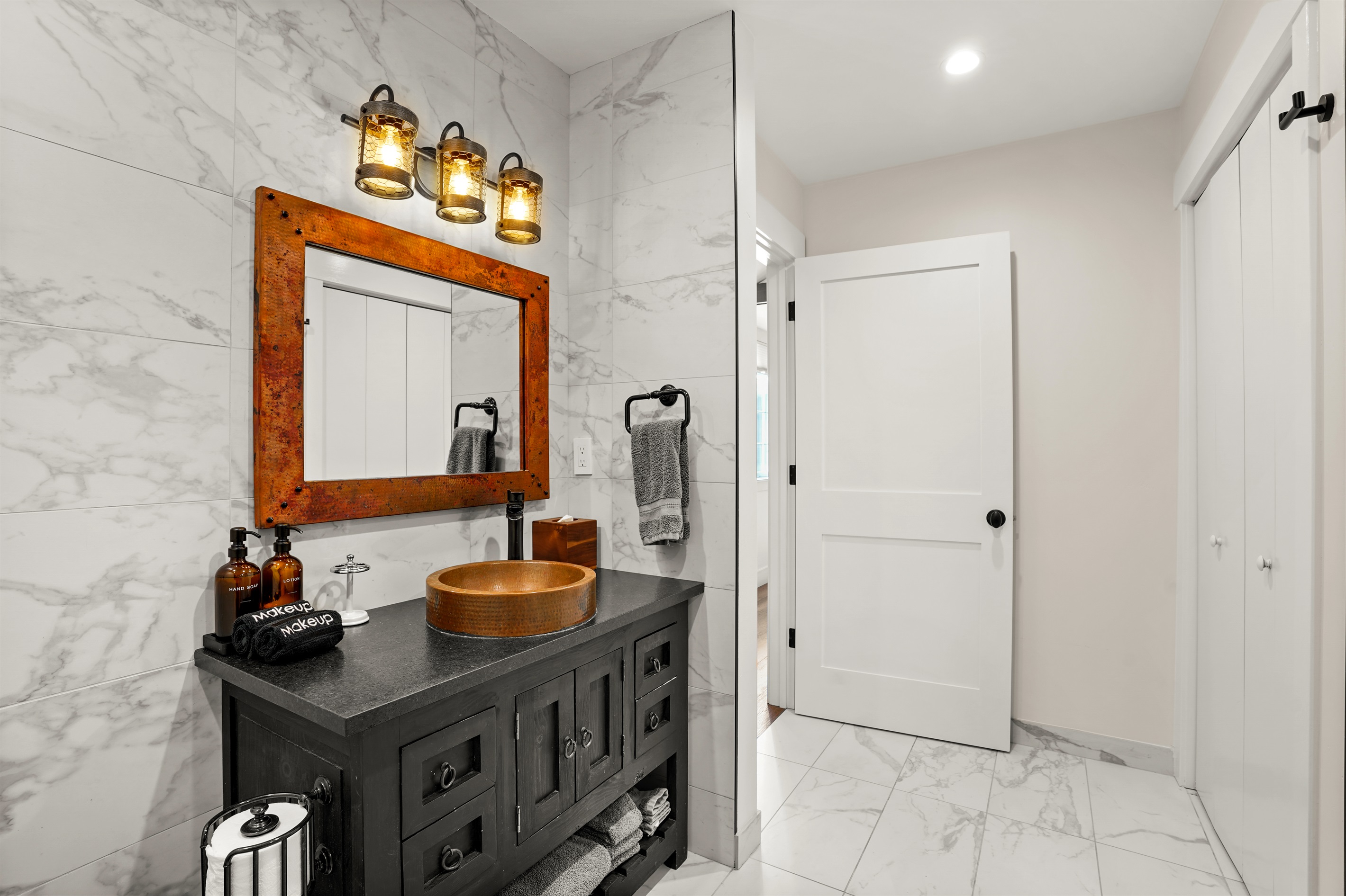 Bathroom with standing shower, toiletries, and bath linens provided