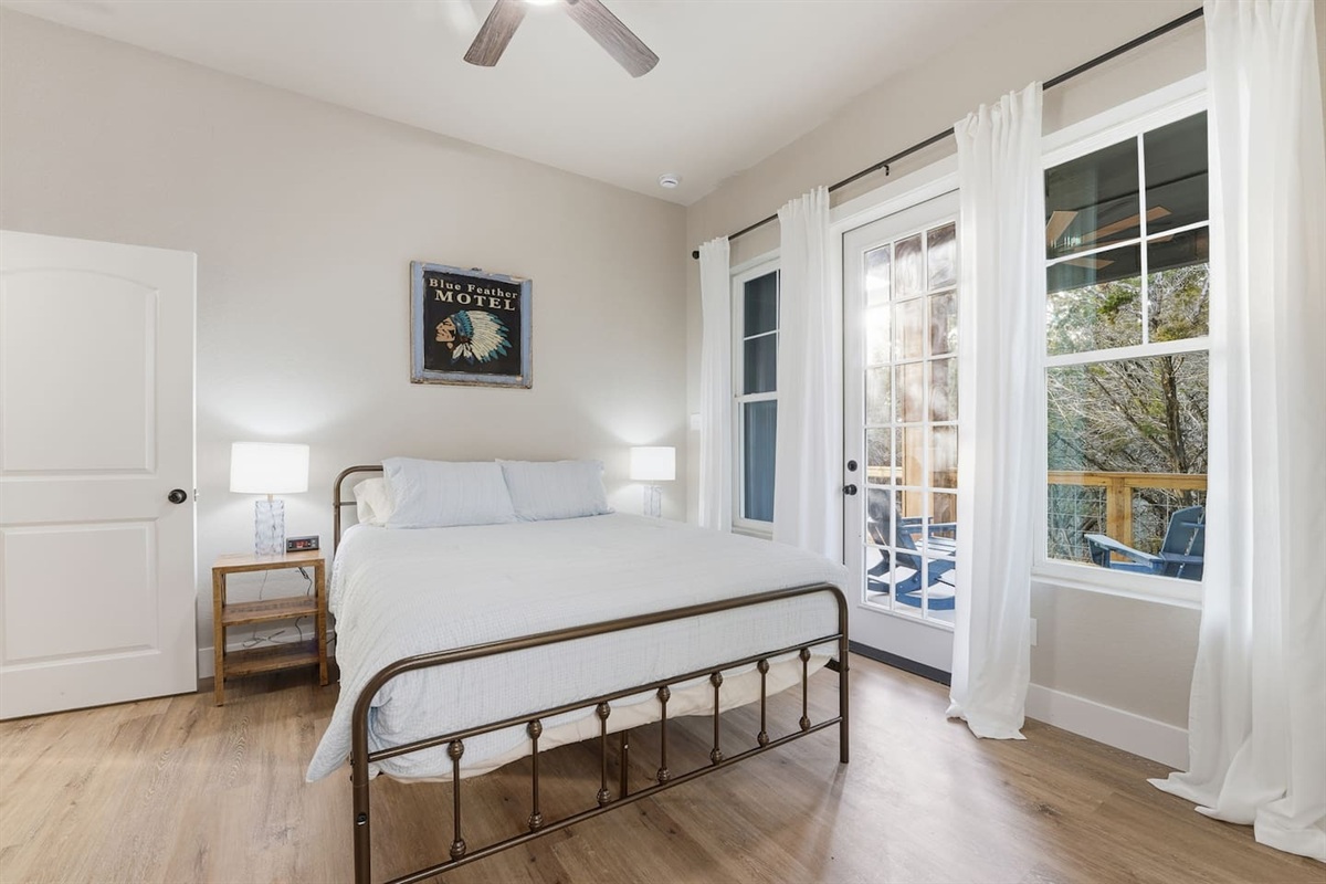 Bedroom Two with deck access and natural light overlooking the surrounding trees.