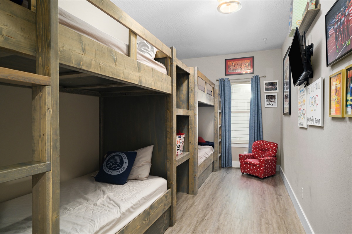 Main level: Olympic Dreams room with two built-in bunk beds, sleeps 4. Bathroom across the hall