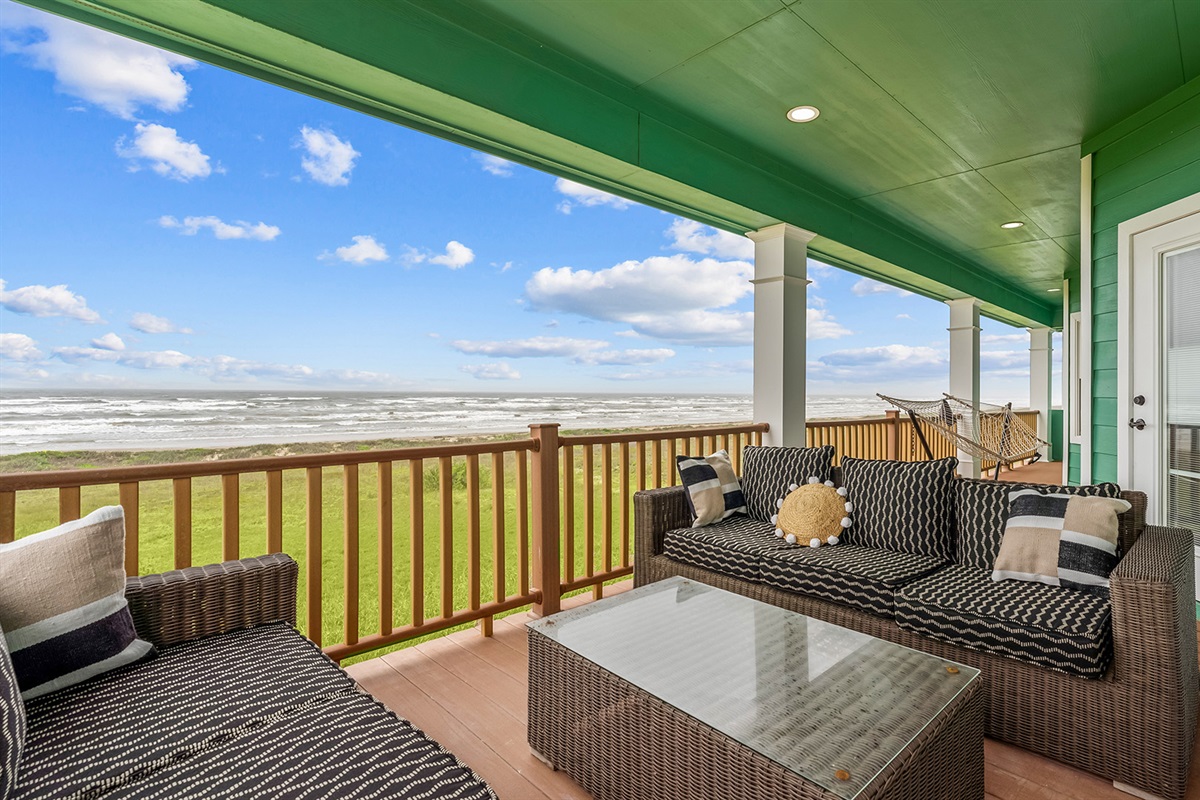 Rear Patio: Additional outdoor living space with comfortable seating and hammocks for relaxing.