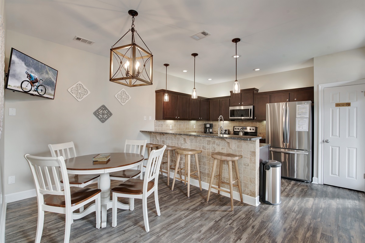Kitchen and dining area with seating for six and pendant lighting