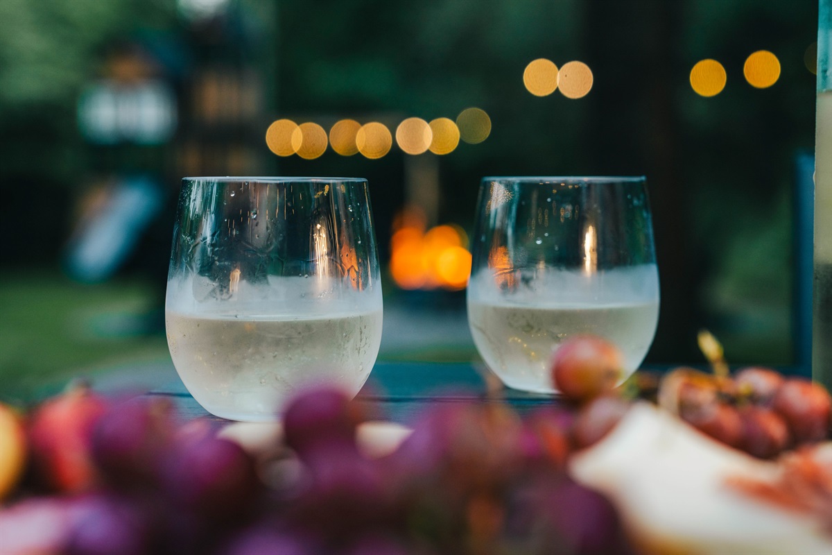 Savor the little moments—wine, fresh air, and a firepit glowing in the distance.