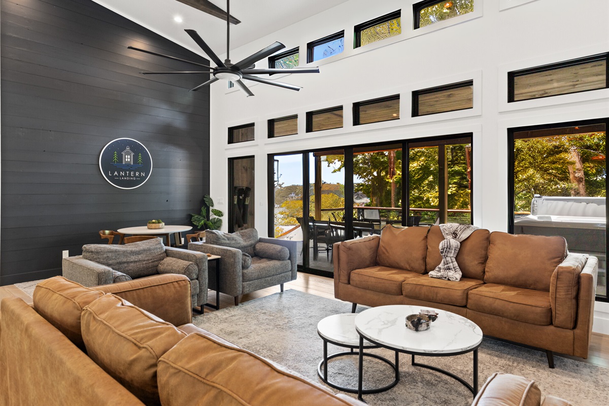 Expansive windows fill the space with natural light, enhancing the cozy yet modern ambiance of the cabin.