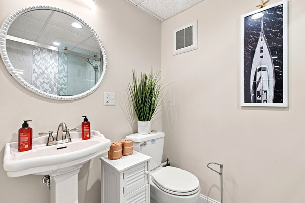 A bright vanity and coastal-inspired details complete this convenient lower-level bathroom.