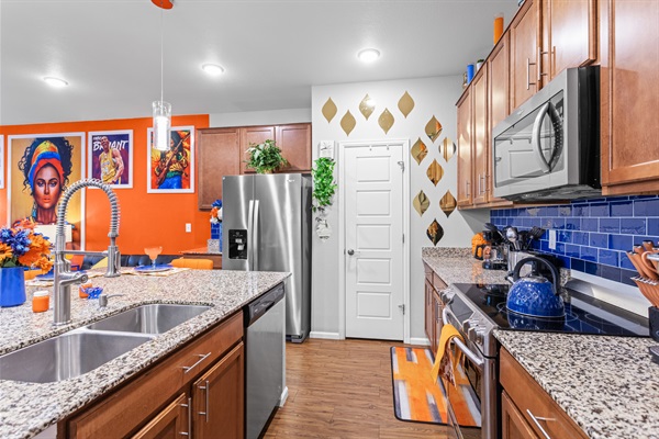 A spacious, fully-equipped kitchen featuring a sleek sink, modern appliances, and ample counter space, designed for convenience and efficiency