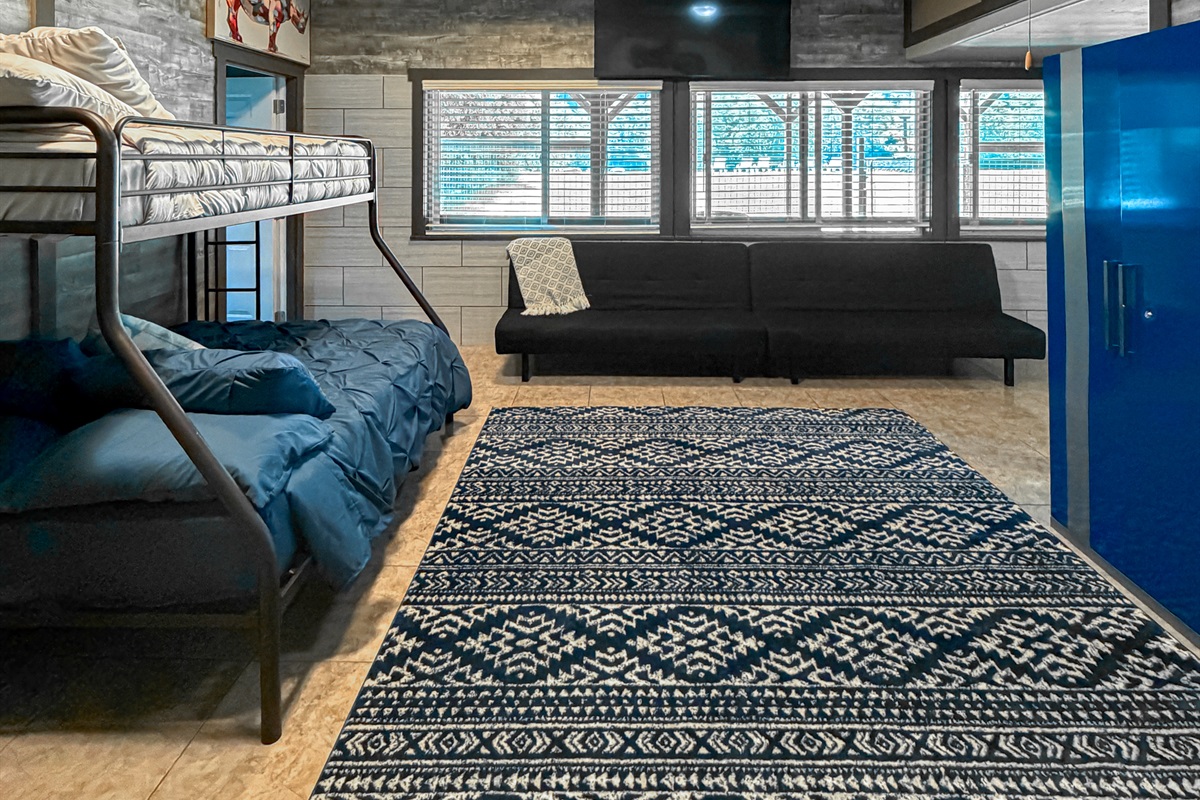 Downstairs Bonus Space featuring pull-out futons for extra guests and a sliding glass door with easy beach access—perfect for enjoying the waterfront lifestyle.