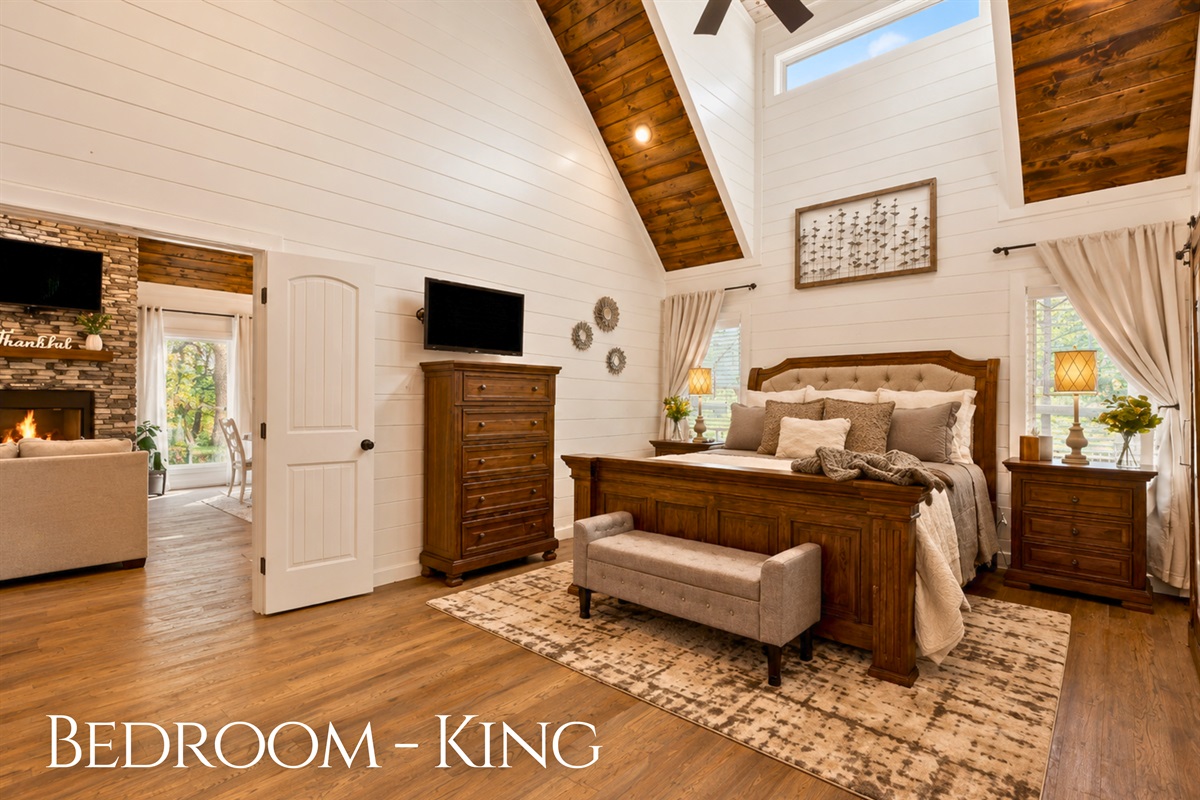 The spacious king bedroom features vaulted ceilings, warm wood accents, and a peaceful atmosphere perfect for restful nights away.