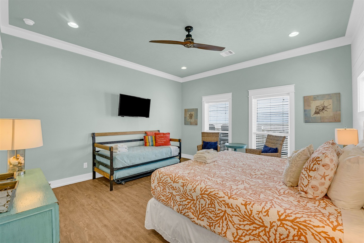 Sea It All: Primary bedroom is well appointed, w/ twin trundle bed, added seating, SMART TV and plenty of natural light. 
