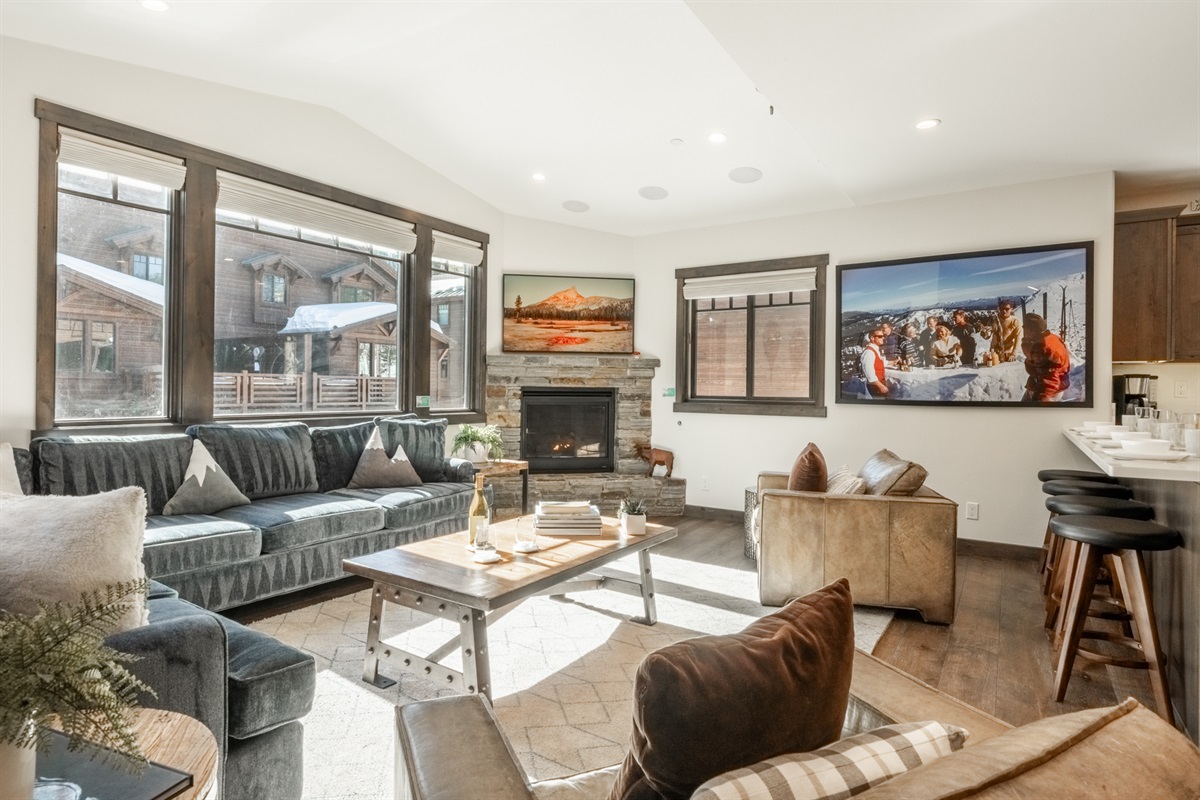 A comfortable sectional sits in warm south-facing light, with easy access to the bar and Slim Aarons photography adding a playful, vintage touch to the space.