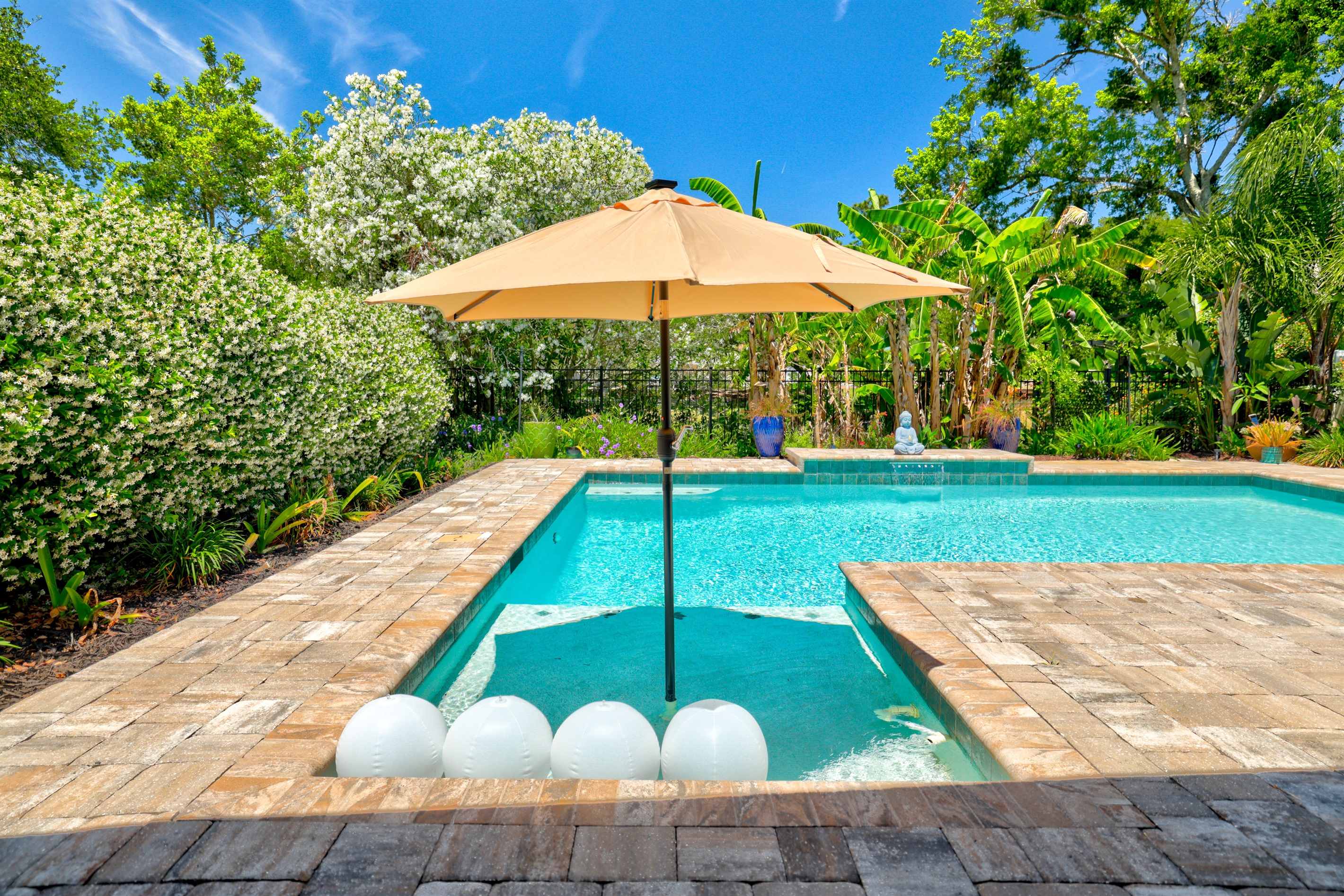 The pool includes a shallow shelf for lounging.