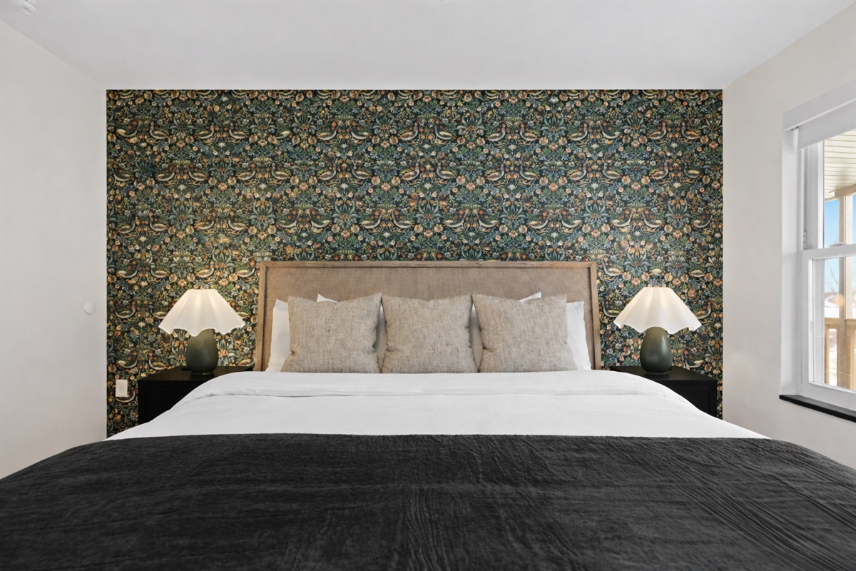 Elegant bedroom with a plush bed, warm bedside lighting, and a stunning accent wall—creating a cozy, boutique-style retreat for restful nights.