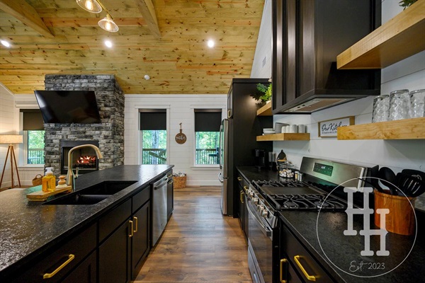 Kitchen is stocked with serving spoons, knife block, can opener, measuring cups