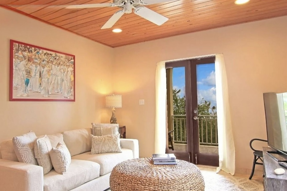 Comfortable lounge with smart TV and balcony access—quiet, cozy, and breezy after beach days.