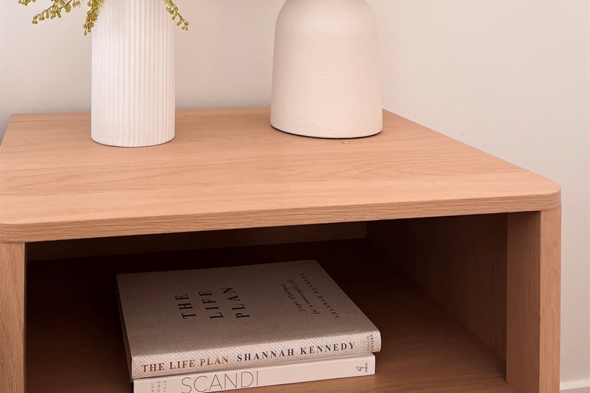 Summers Green View Retreat in Logan Reserve keeps the bedroom details simple, with a side table set beside soft bedding and warm light.