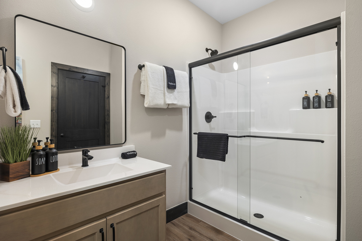 A glass walk-in shower and black fixtures in the ensuite.