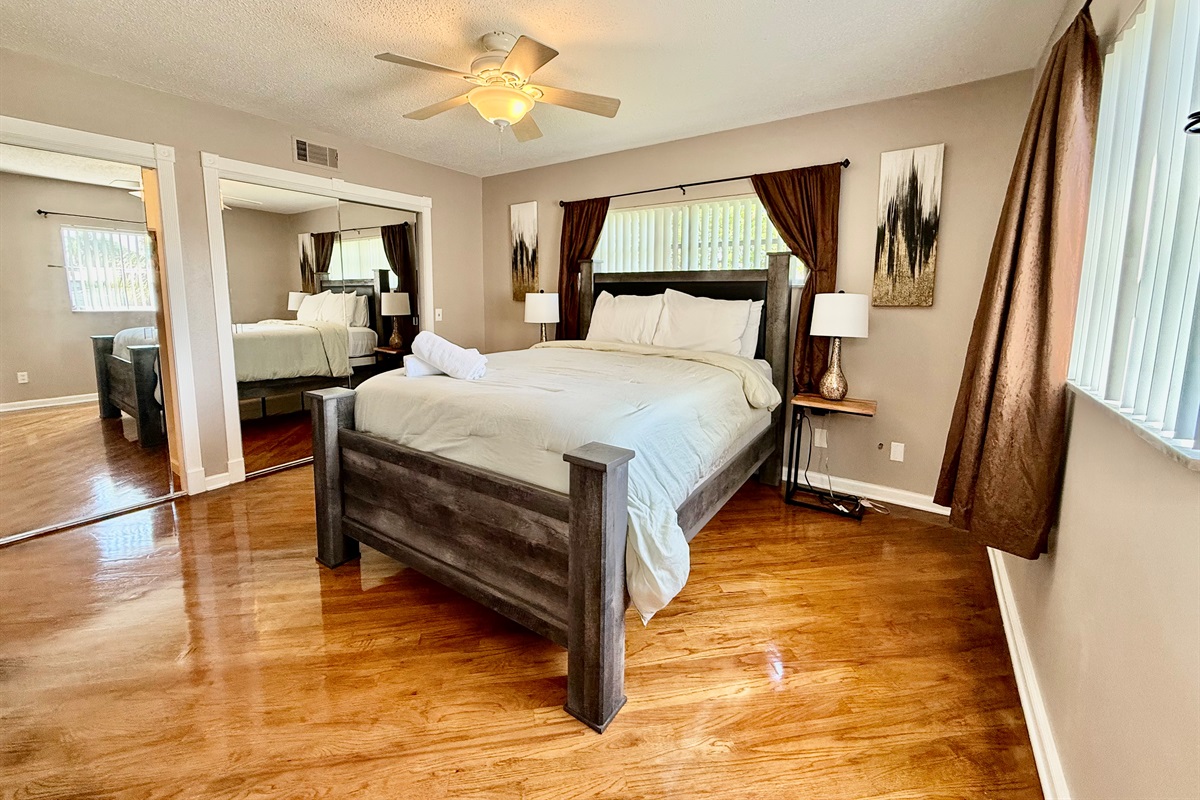 This beautifully furnished bedroom features a plush bed, rich wood floors, and cozy neutral tones—perfect for a peaceful night’s rest.