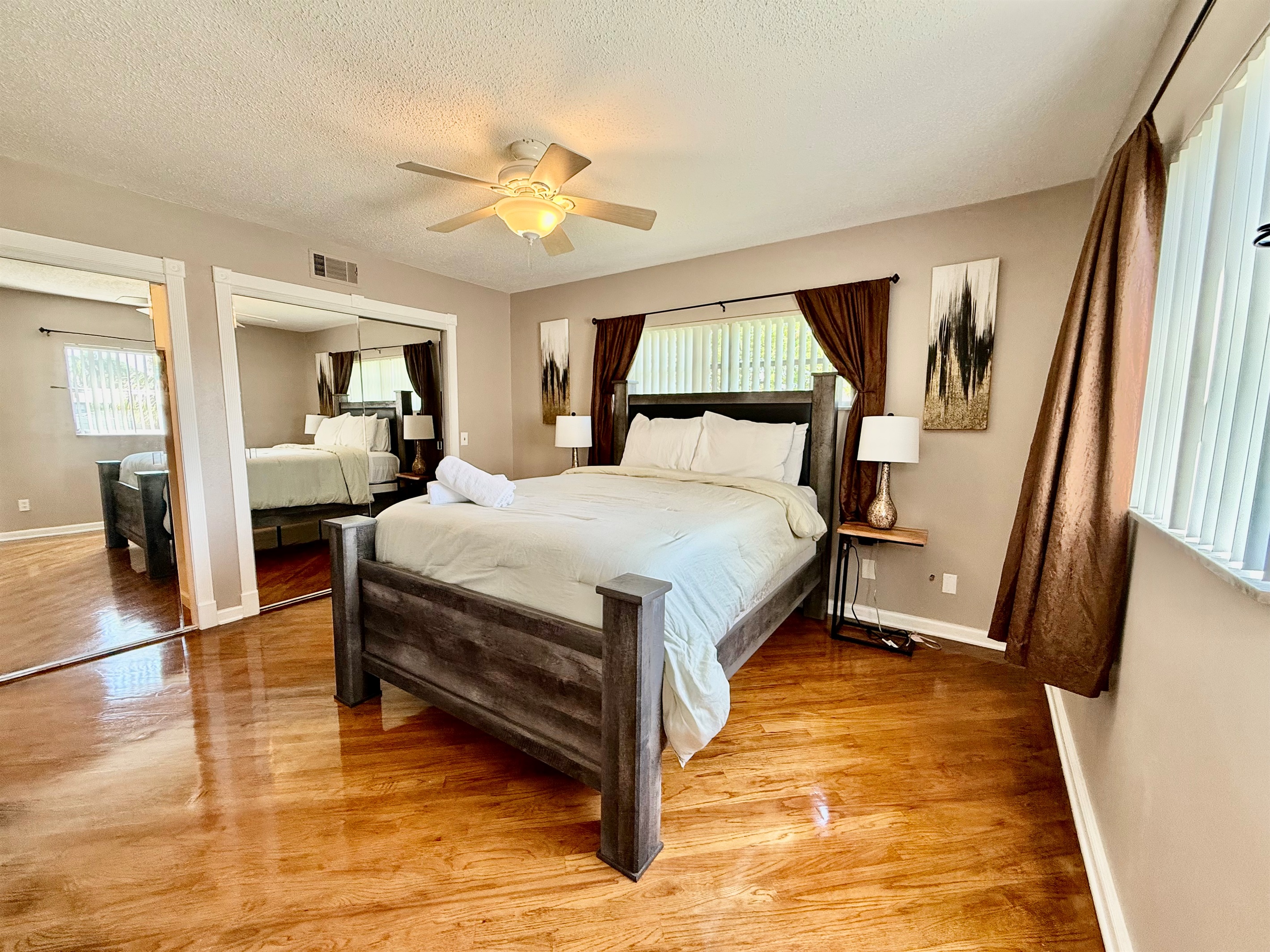 This beautifully furnished bedroom features a plush bed, rich wood floors, and cozy neutral tones—perfect for a peaceful night’s rest.