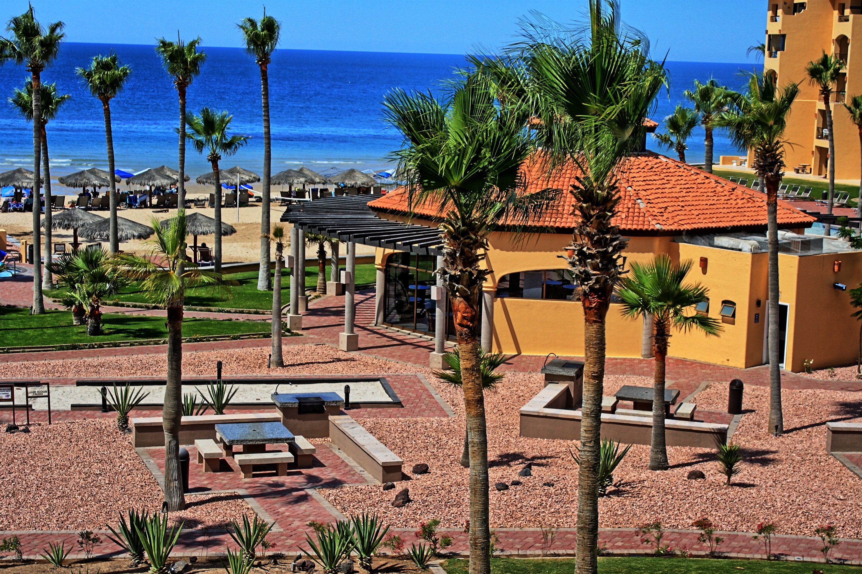 resort grounds with bbq areas, club house looking out to the beach and sea